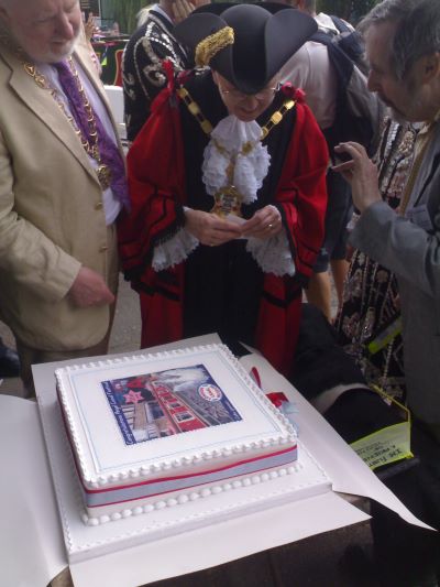 Mayor looks over a decorated square cake