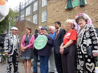 A group of people hold a green plaque in memory of Crystal Hale