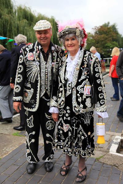 Man and woman in dark costumes studded with jewels