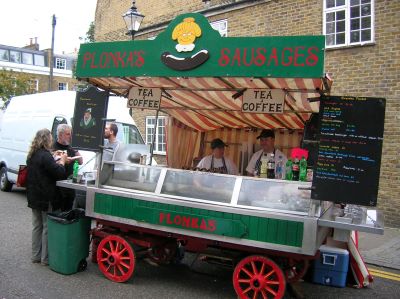 A mobile sausage stall with colourful wheels and paintwork