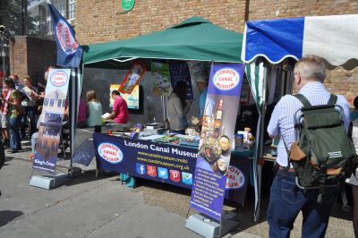 A stall under a gazebo with advertising banners