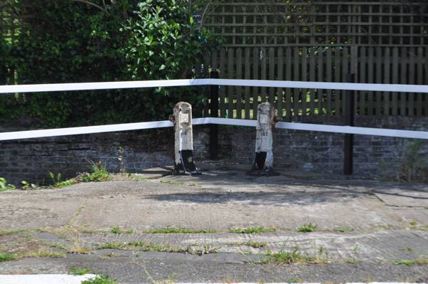 Side pont baddles beside lock but brick wall and garden behind