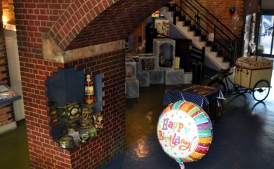 pier of faux brick arch with display case and happy birthday balloon
